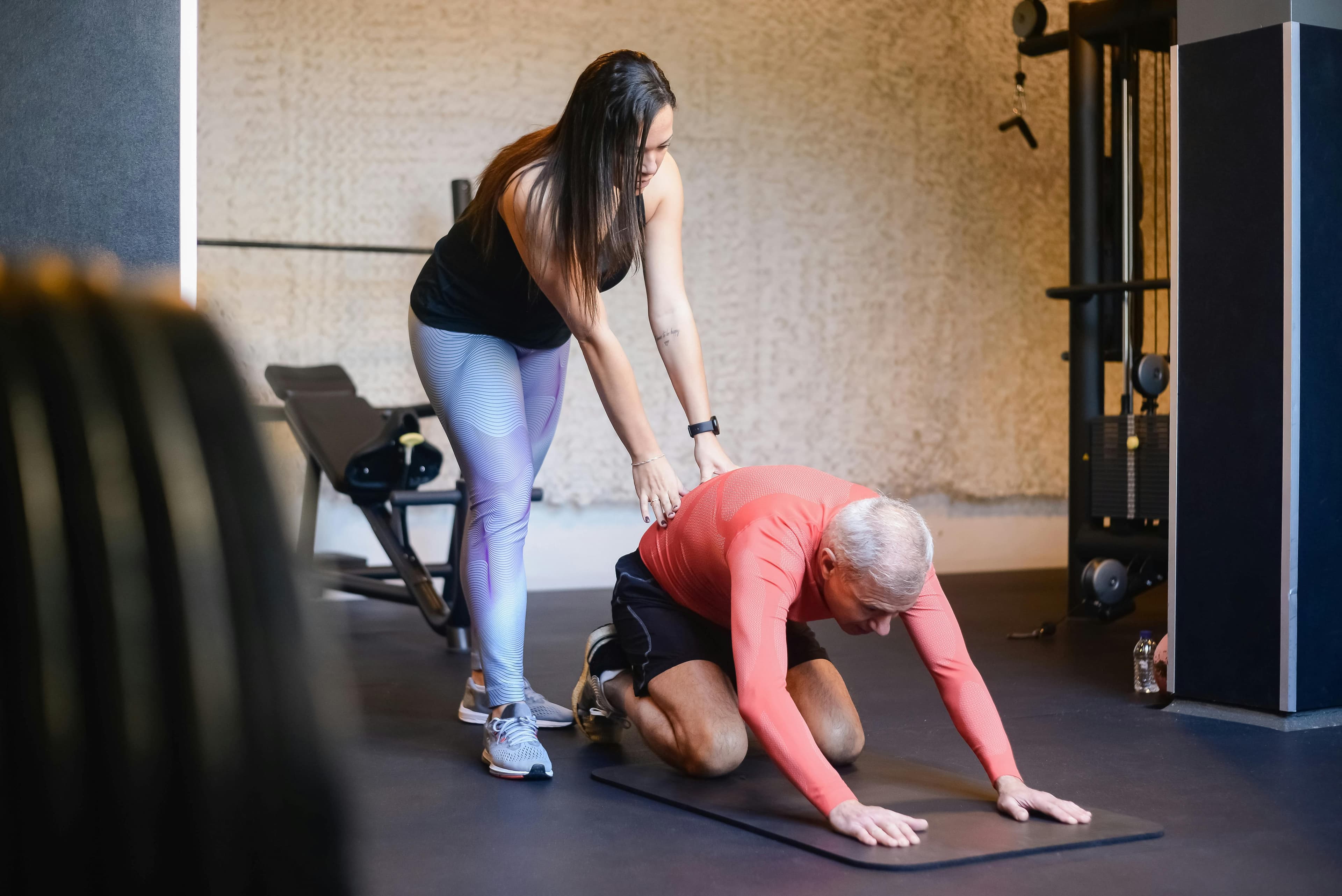 A professional guiding an older adult through an exercise